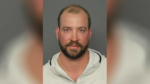 Mug shot of a middle-aged bald man.